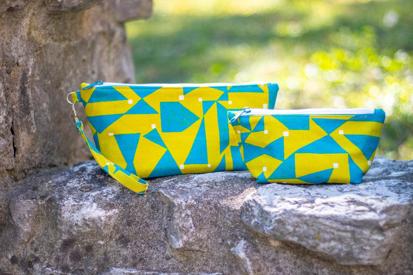 Image of yellow and blue Rivet Patterns Prelude Pouch sitting on rock