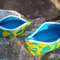 Image of yellow and blue Rivet Patterns Prelude Pouch sitting on rock
