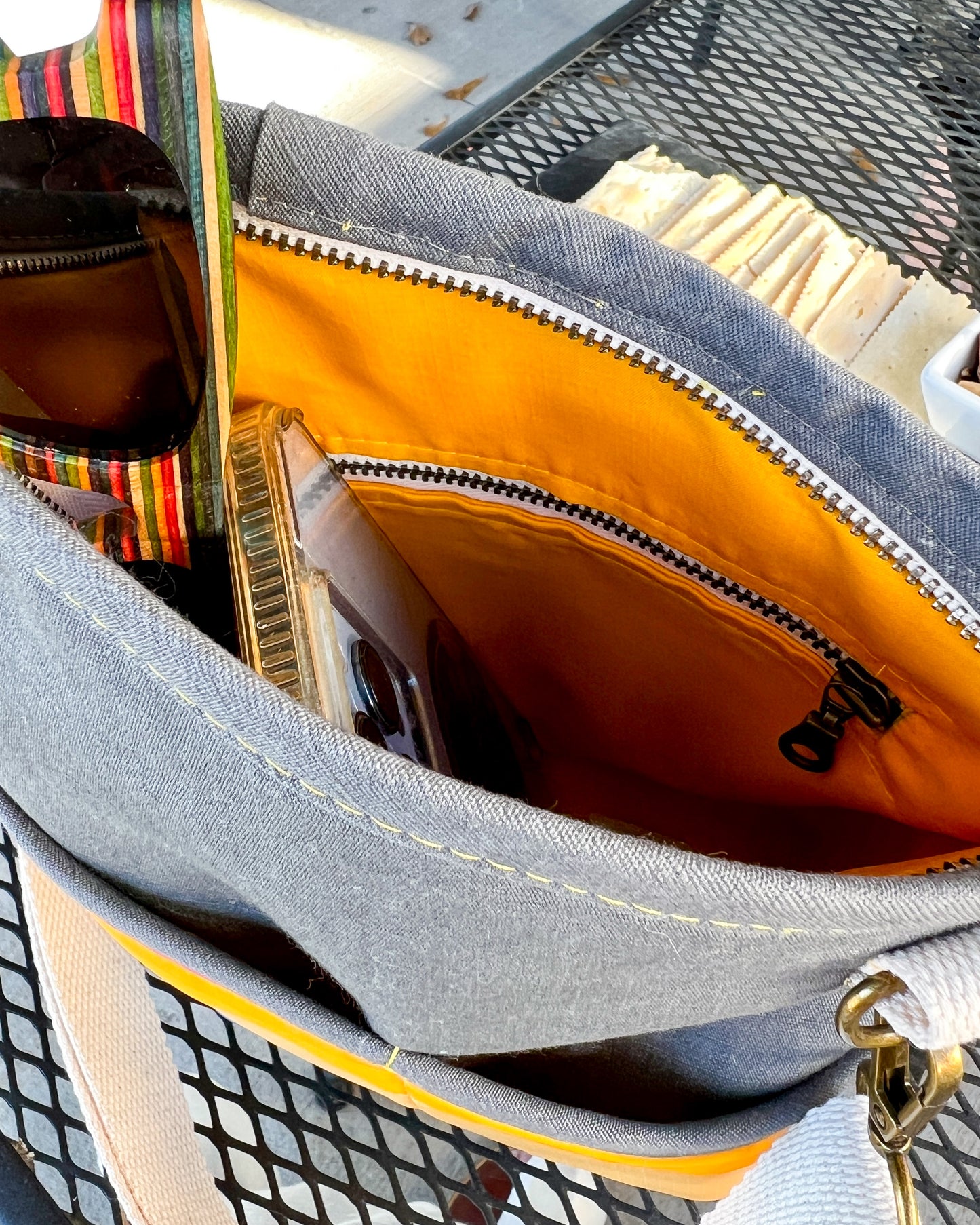 Image of inside opening of pink, yellow and blue Rivet Allegro Crossbody Bag